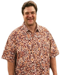 A man wearing a short-sleeve button-up shirt with a brown, orange, and beige tribal-style pattern, set against a plain white background.